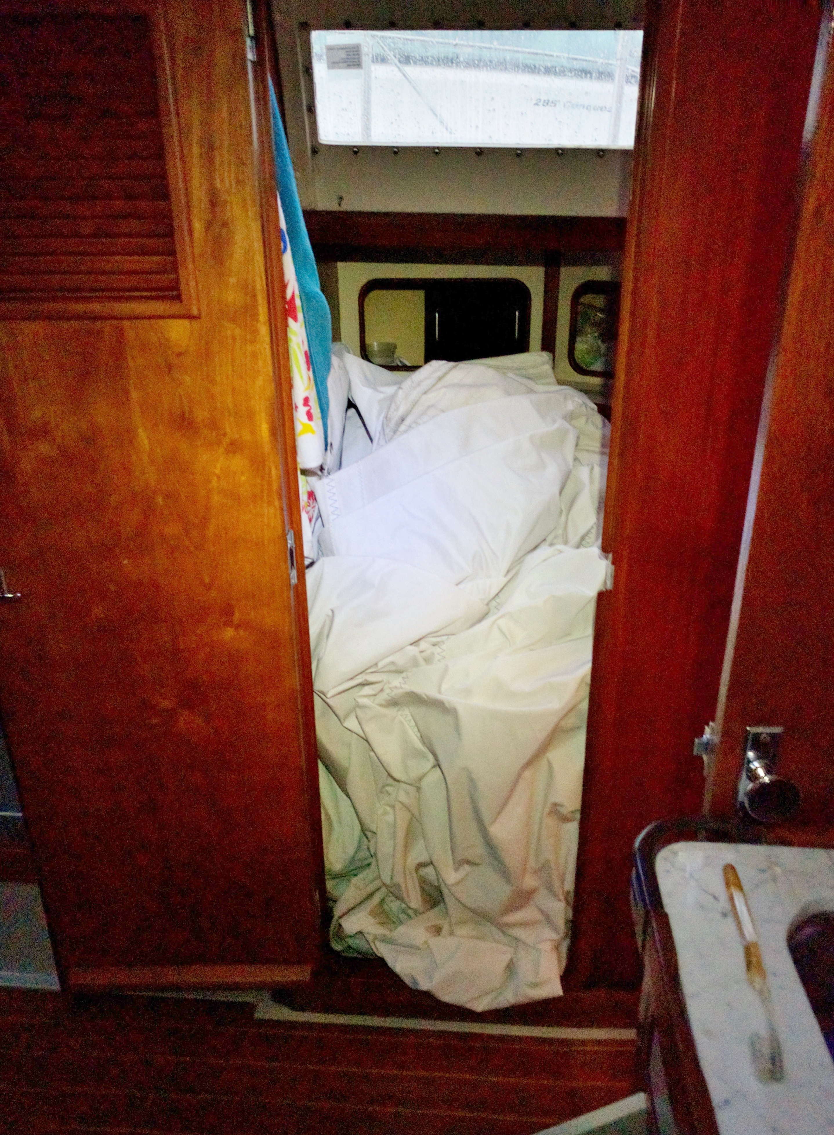 This was the first time we had taken the genoa down! Dumbly, we didn't fold it, and found lugging a heavy unwieldy large sail into the cabin was really difficult. And the head was the best place to store it out of the way of other projects!